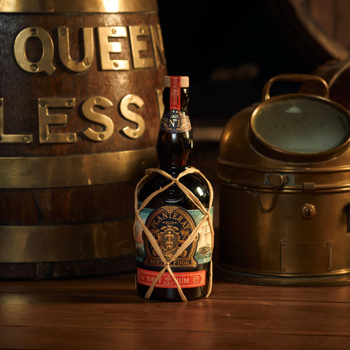 Bottle of whiskey with decorative rope label on a wooden surface with vintage metal containers in the background.