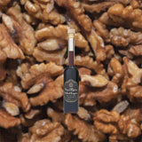 Bottle of Bottle of Nux Alpina Walnut Liqueur over backdrop image of walnuts.