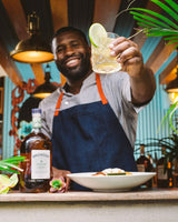 Man holding a cocktail with a bottle of Appleton Estate rum in a bar setting