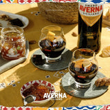 Two glasses of Amaro Averna Siciliano on a table with a bottle and small bowl of the liquor.