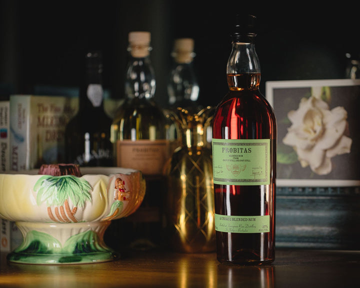 Bottle of Probitas rum on a table with other bottles and decor in the background