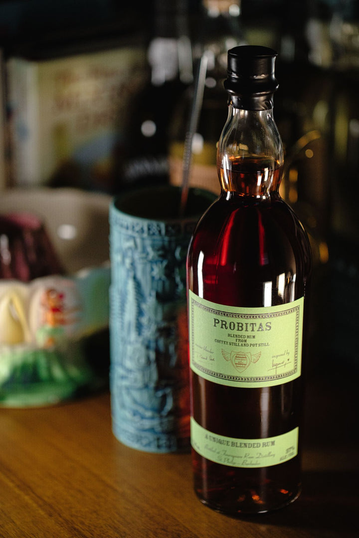 Bottle of Probitas rum on a wooden surface with blurred background