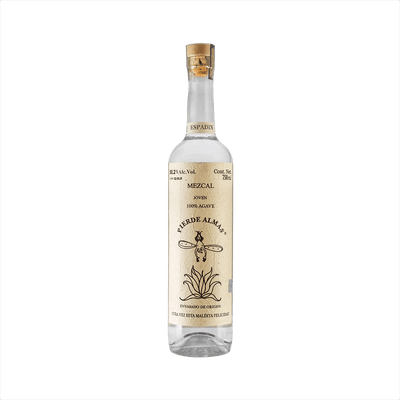 A tall thin bottle of mezcal with a craft paper label that reads: Mezcal Joven 100% Agave Pierde Almas. There is an simple illustration of a devil like character with wings diving blissfully into an agave plant.