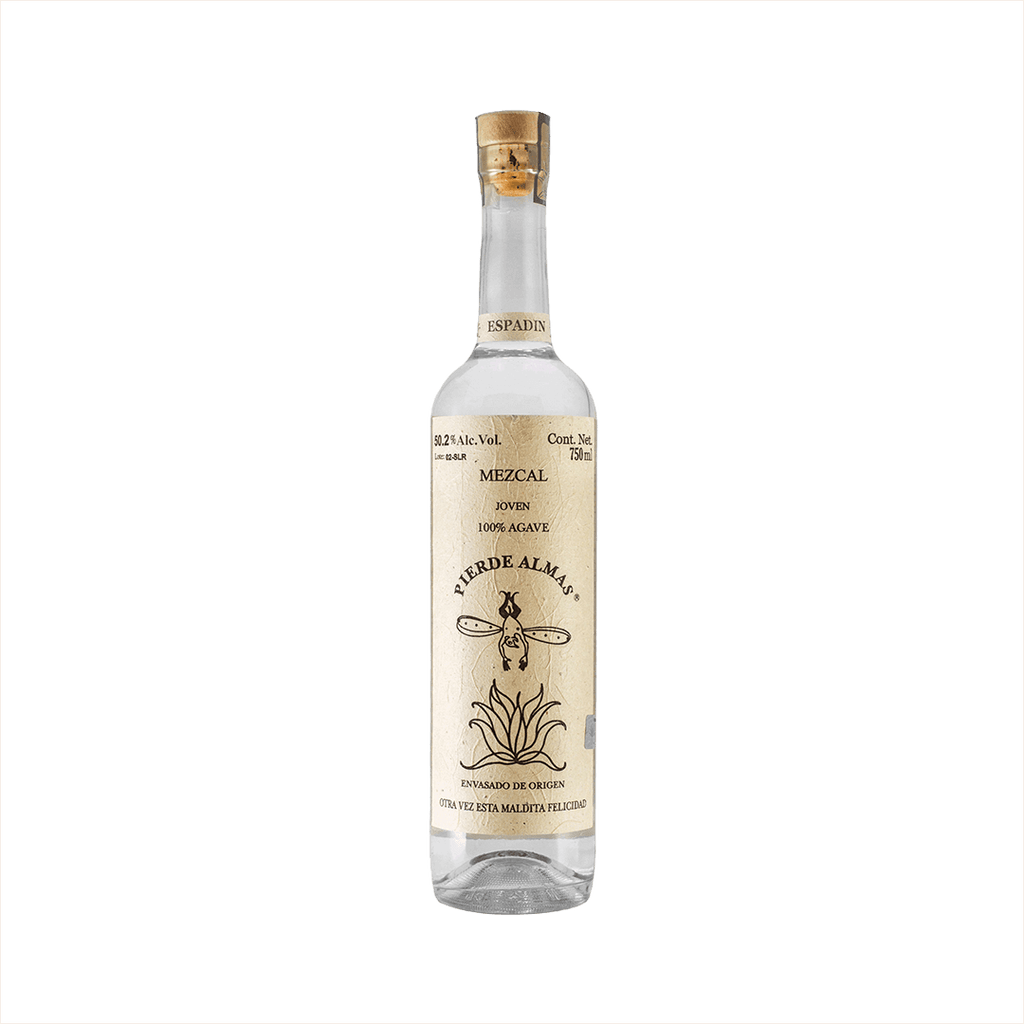 A tall thin bottle of mezcal with a craft paper label that reads: Mezcal Joven 100% Agave Pierde Almas. There is an simple illustration of a devil like character with wings diving blissfully into an agave plant.