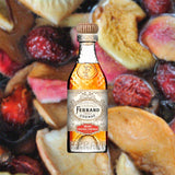A bottle of Pierre Ferrand Original Formula with a clear amber-colored liquid visible and the brand's logo on the label over backdrop of fruits.
