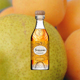 A bottle of Pierre Ferrand Cognac Ambre with a clear amber-colored liquid visible and the brand's logo on the label over backdrop of fruits.
