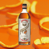 Bottle of Ferrand Dry Curacao liqueur with orange peels in the background