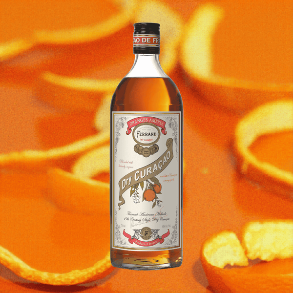 Bottle of Ferrand Dry Curacao liqueur with orange peels in the background