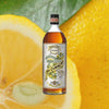 A bottle of yellow liqueur, with an ornate label. It reads Pierre Ferrand Dry Curacao Yuzu. There is a banner above that reads: Yuzu Late Harvest Limited Edition. Set again a macro shot of a slice of yuzu and a whole yuzu fruit with leaves.