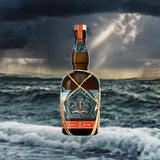 Bottle of Planteray Mister Fogg Navy Rum Sail No 1. over back drop image of a stormy ocean.