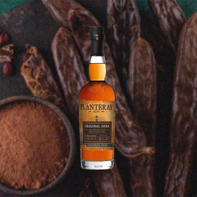 Bottle of Planteray Original Dark Barbados Jamaica Rum - formerly Plantation - against a backdrop of dried tobacco and cocoa powder.