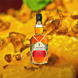 Bottle of Planteray Xaymaca Special Dry Jamaican Rum over a crystallized honey background image.