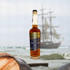 Bottle of Privateer Navy Yard 4 Year Aged Rum over backdrop image of a sail boat.