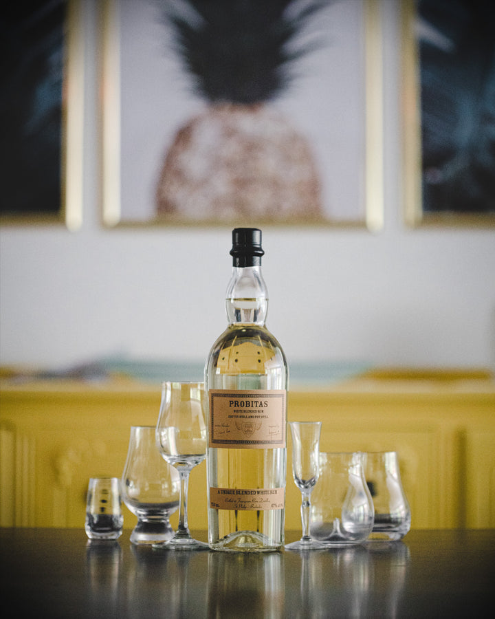 Bottle of Prohita whiskey with glasses on a table in a stylish room.