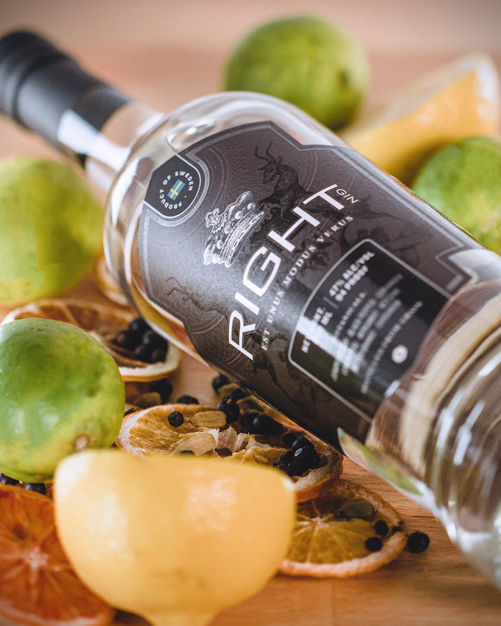 Bottle of 'Right Honour Vetus' gin surrounded by fruits on a wooden surface