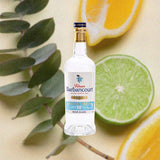 Bottle of Rhum Barbancourt Haitian Proof White Rum 110 Proof over backdrop image of lemons and limes.