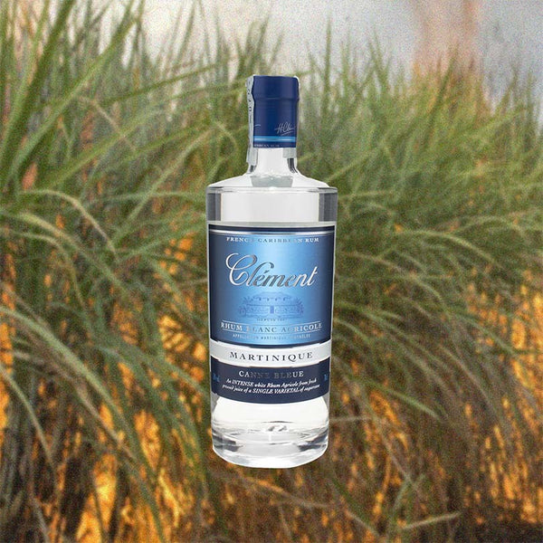 Bottle of Rhum Clément Canne Bleue over backdrop of grass.