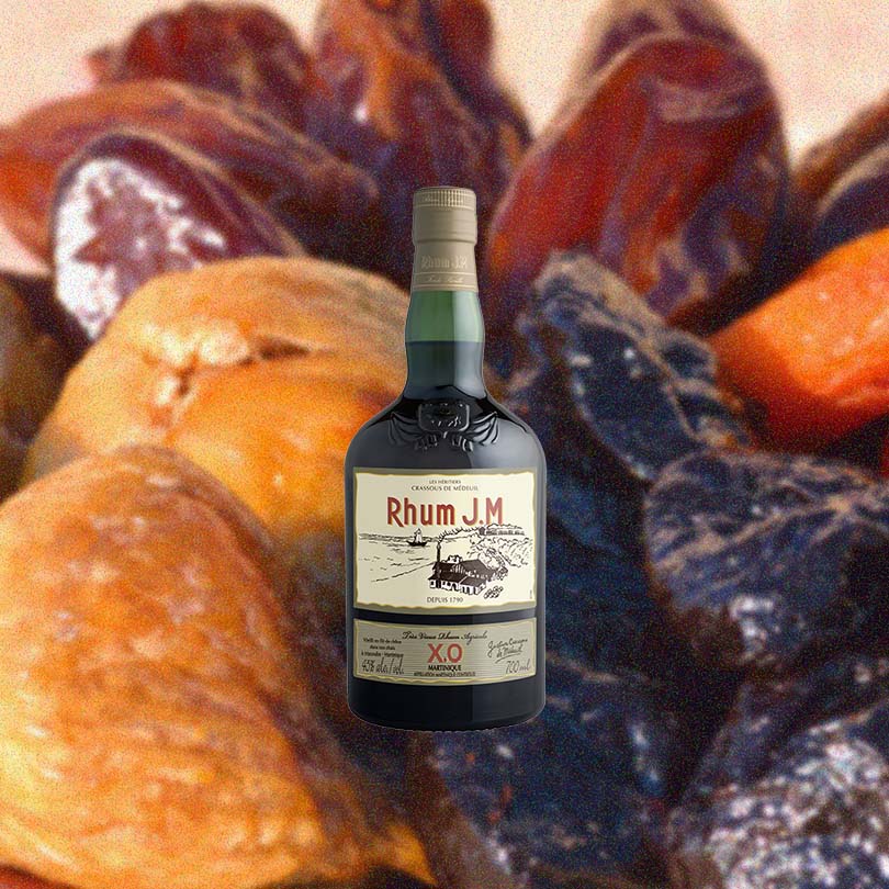 Bottle of Rhum J.M XO Agricole Rhum over backdrop image of dried fruits.