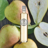 A bottle of Rothman & Winter Orchard Pear set against a backdrop of freshly-picked pairs, whole and in halves, surrounded by pear leaves.