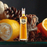 Bottle of SIA Scotch Whisky over background image of an orange, pinecone and other spices.