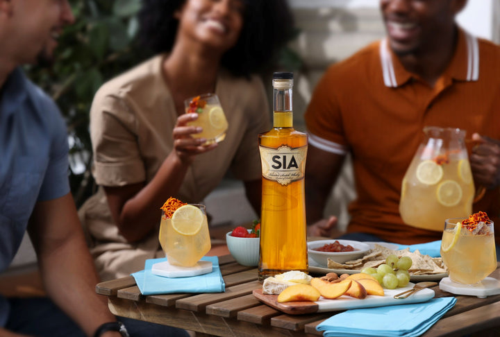 People enjoying a meal with SIA branded drinks and food on a wooden table.