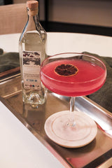 Cocktail with a red rim and bottle of Etier on a tray