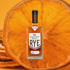 Bottle of Sagamore Spirit Rye Whiskey over backdrop image of an orange.