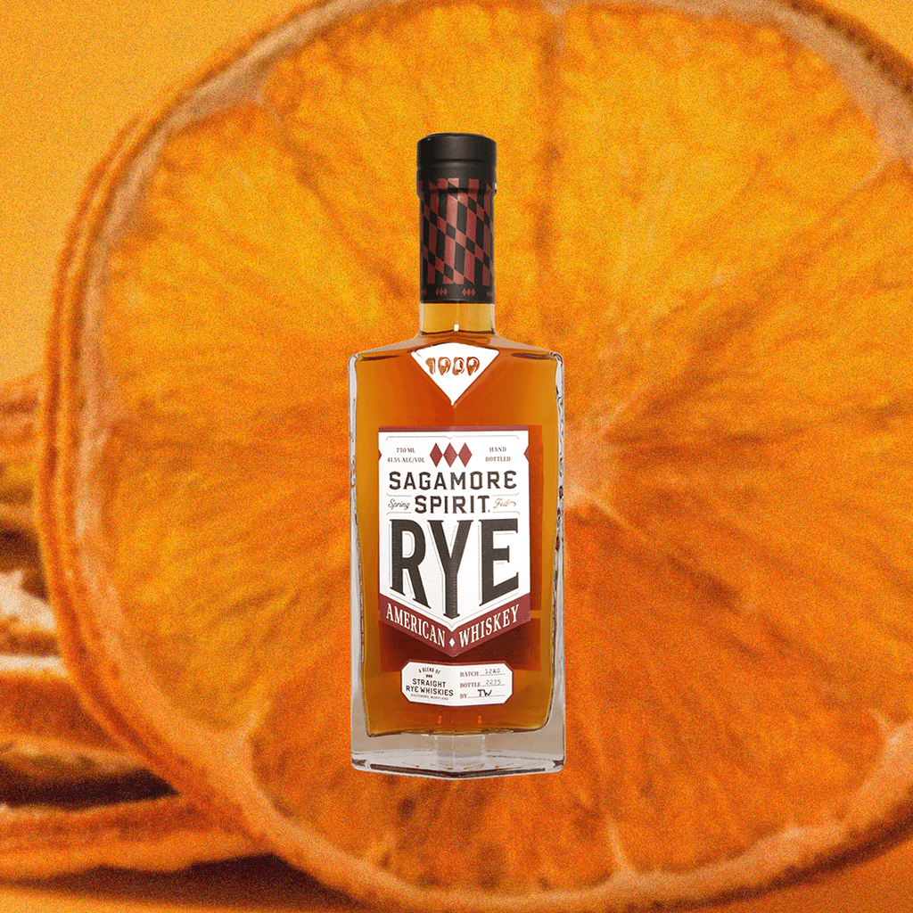 Bottle of Sagamore Spirit Rye Whiskey over backdrop image of an orange.