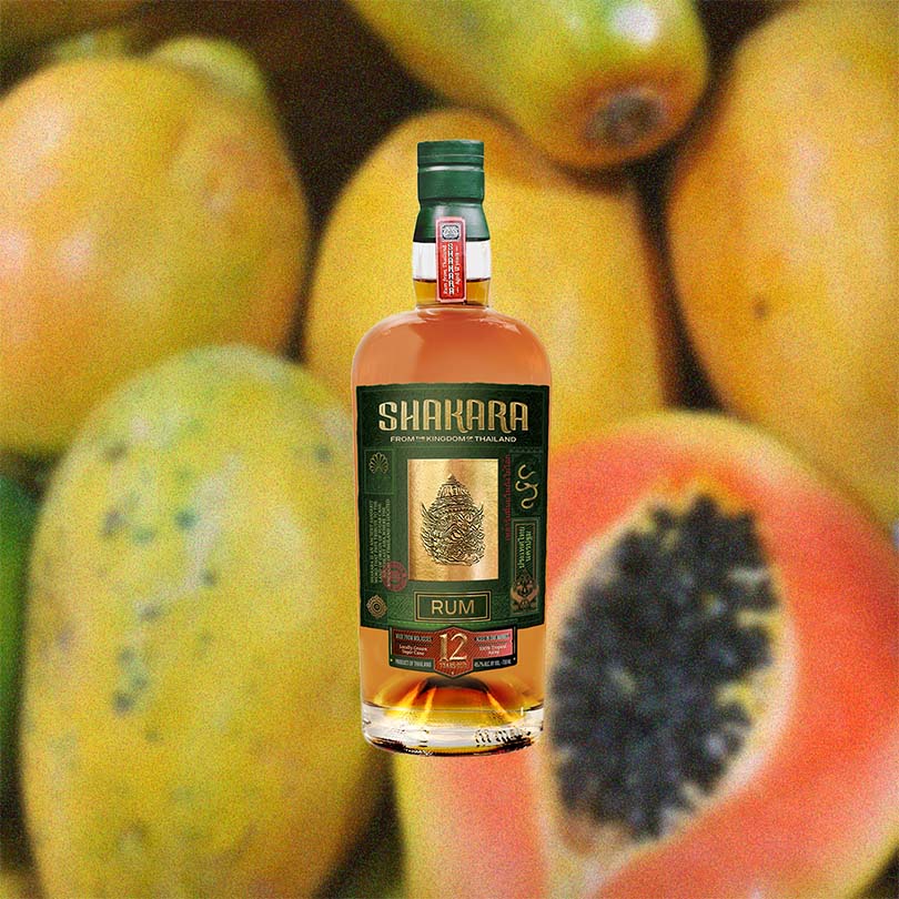 Bottle of Shakara 12 Year Old Rum over backdrop image of fruit.