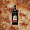 Bottle of Slane Triple Casked Irish Whiskey over backdrop of up close baked pastry.