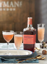 Hayman's gin bottle with cocktails on a tray against a branded background