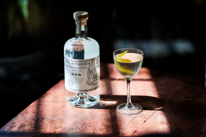 Bottle of Old Forester gin with a cocktail on a wooden surface