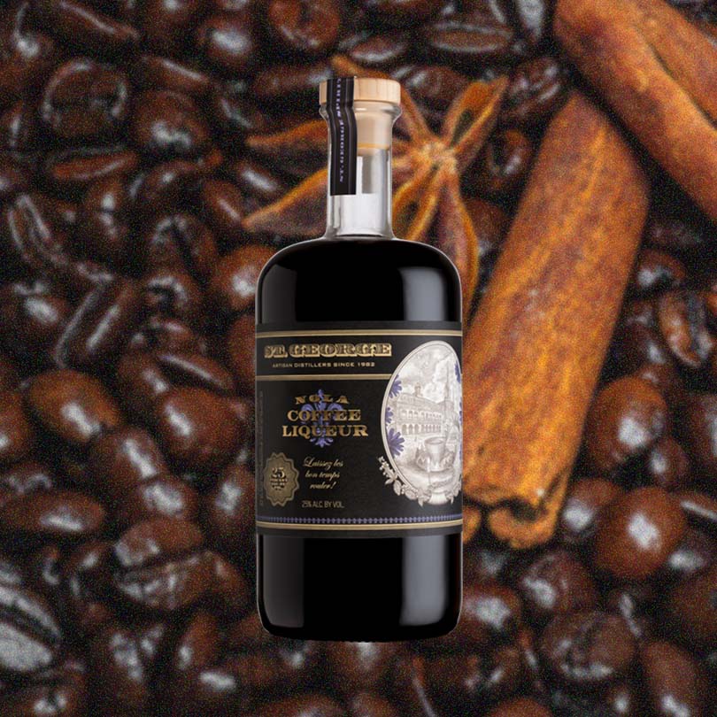 A dark rich liquid in a beautiful, apothecary shaped bottle. The label reads NOLA Coffee Liqueur. There's a sepia toned illustration of an old style Spanish buildings in an oval emblem on the bottle. Against a backdrop of rich coffee beans, with star anise and cinnamon sticks.