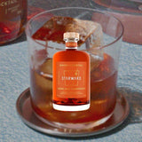 A macro shot of an Old Fashioned with a bottle of Starward's (New) Old Fashiioned Whisky Cocktail on top.