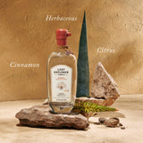 Bottle of The Lost Explorer Tequila on a rock in front of a yellow wall.