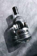 Bottle of Tanglin Black Powder Gin on a textured gray surface