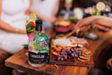 Tanglin Singapore Gin bottle on a wooden table with food and drinks in the background