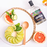 Bottle of Tanglin Singapore Dry Gin with citrus fruits on a white background