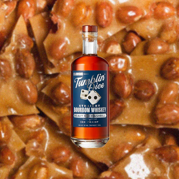 Bottle of Tumblin' Dice Heavy Rye Bourbon 100 Proof over backdrop image of brittle.
