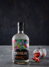 Bottle of Tanglin Singapore Gin on a dark background with a colorful label.