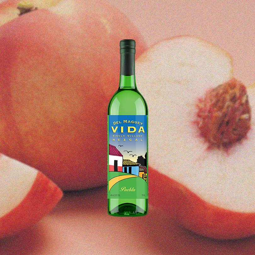 Bottle of Del Maguey VIDA Puebla Mezcal over backdrop of sliced apples.