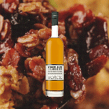 Bottle of Bottle of Widow Jane Paradigm Rye over backdrop image of candied nuts and raisins.