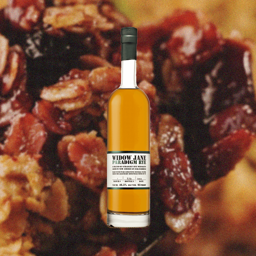 Bottle of Bottle of Widow Jane Paradigm Rye over backdrop image of candied nuts and raisins.