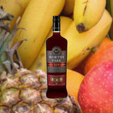 A bottle of Worthy Park 109 Jamaican Rum set against a backdrop of tropical fruits: pineapple, banana , orange.