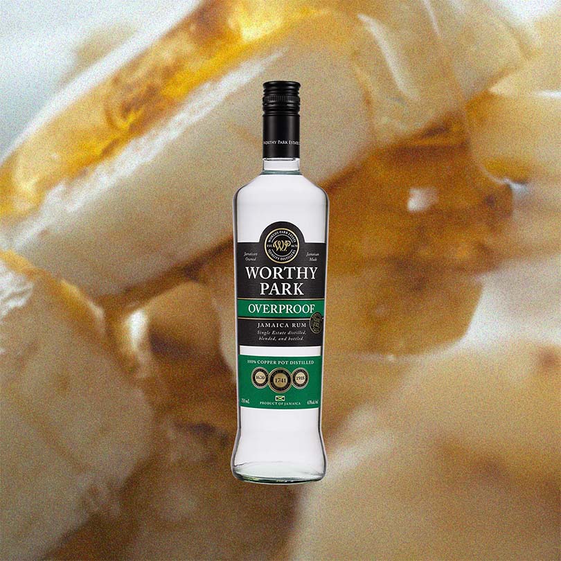 Bottle of Worthy Park Overproof Jamaica Rum over back drop image of Bananas.