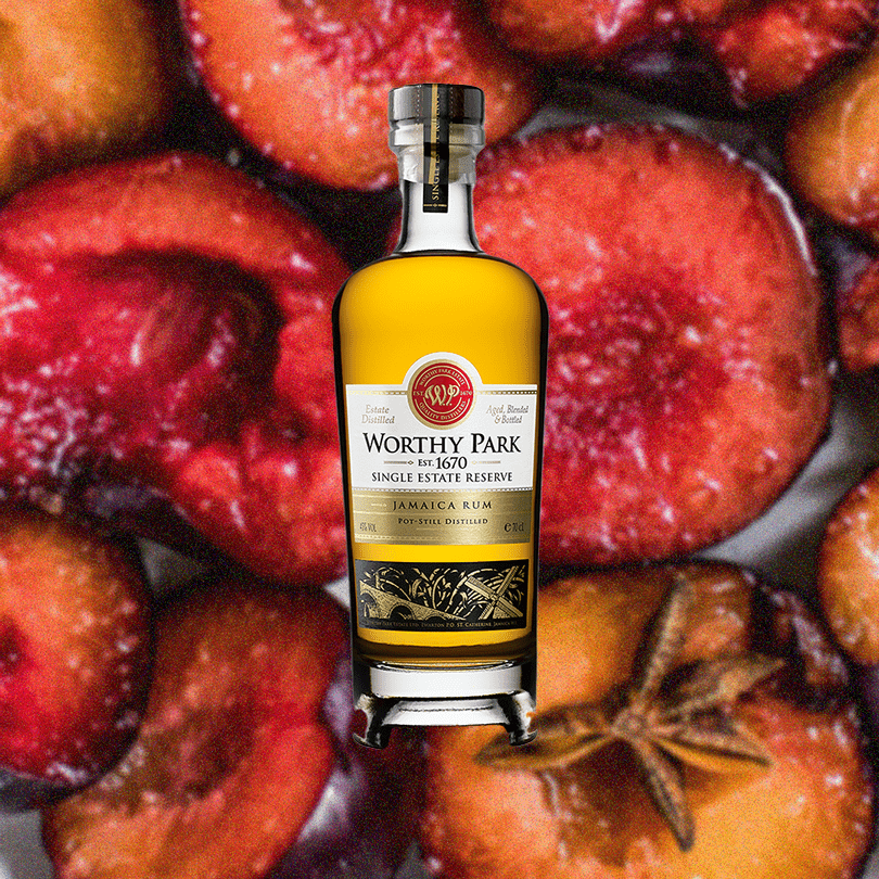 Worthy Park Jamaica Rum bottle with plums and star anise on a textured surface