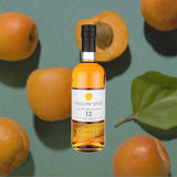 Bottle of Yellow Spot Irish Whiskey over backdrop image of peaches.