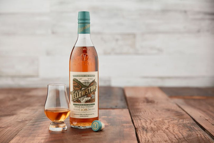 Bottle of Yellowstone American Single Malt Whiskey on a table next to a sniffer of whiskey.