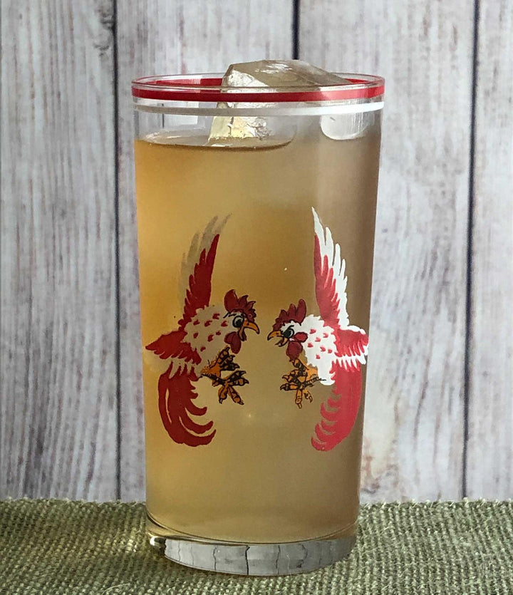 Tumbler with rooster design on a wooden surface