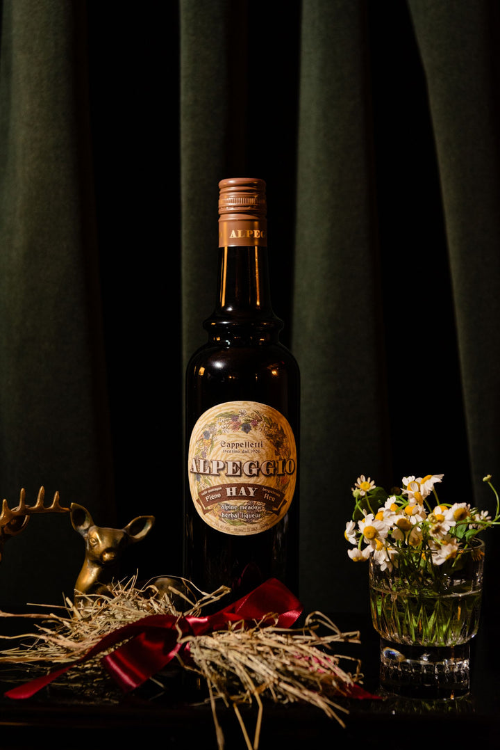 Bottle of Alpena Hay whiskey with decorative elements on a dark background